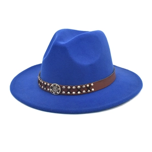 Detail of royal blue fedora hat with leather band, silver studs and gear emblem