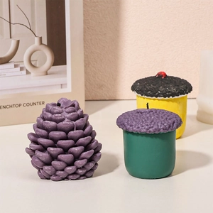 Macro view of purple pinecone candle with detailed paraffin wax texture on tabletop