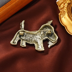 Antique gold terrier dog brooch back view with pin fastener on vintage velvet background