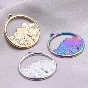 Detailed view of round mountain forest charms in gold, silver and rainbow finishes