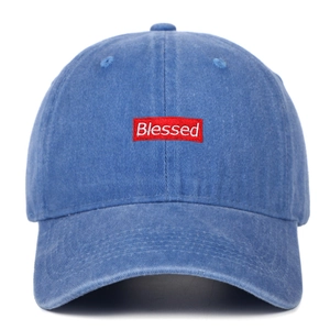 Close-up of blue washed cotton baseball cap with red Blessed box logo embroidery