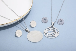 Detailed silver stainless steel necklace and earrings set featuring mama engraving on blue background