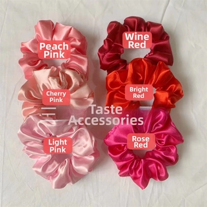 Detail view of six assorted satin scrunchies in shades of pink and red colors