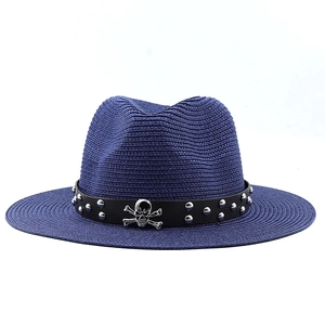 Detail of dark blue woven fedora featuring black leather band with silver skull emblem