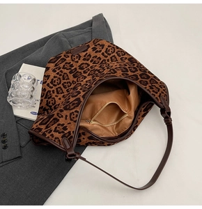 Detail view of leopard print tote bag interior featuring brown satin lining and zip pocket