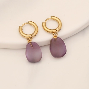 Gold hoop earrings with purple stone pendants and cross charms on white background