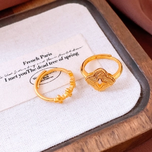 Detail of vintage gold-plated clover and starburst ring set with adjustable bands