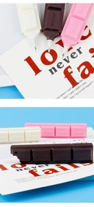 Detail of creative chocolate-shaped ballpoint pens in white, brown, and pink finishes