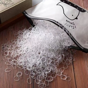 Detailed macro view of clear disposable hair bands in a cute cartoon penguin zipper bag