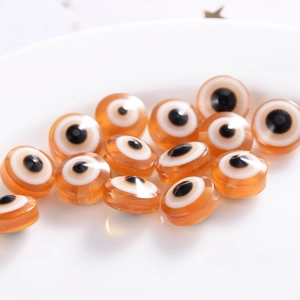 Macro shot of orange resin evil eye beads for handmade jewelry DIY crafts and accessories
