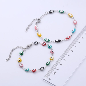 Macro detail of silver evil eye bracelet with colorful enamel beads and lobster clasp