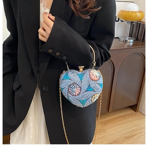 Detailed view of heart-shaped sequin evening bag with embroidery on a black blazer