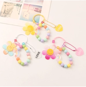 Detail of DIY macaroon colored keychains with smiling flower and heart pendants