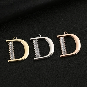 Detailed view of rhinestone D-letter pendants in gold, silver, and rose gold finishes