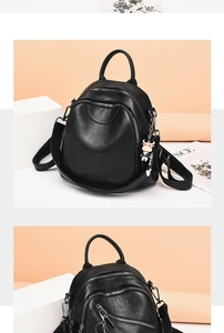 Detail view of black faux leather backpack featuring textured finish and HELLO charm