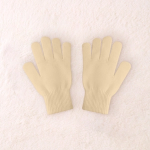 Detailed close-up of cream knit gloves with ribbed cuffs on a white plush background