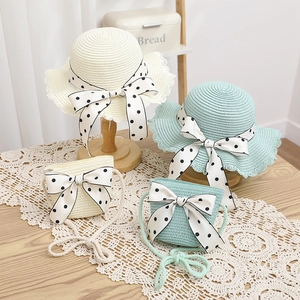 Straw sun hat and matching crossbody bag set with polka dot bow and wavy brim