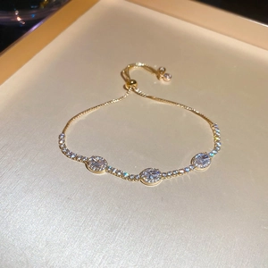 Detail of adjustable gold bracelet featuring oval zircons and micro-pave crystals