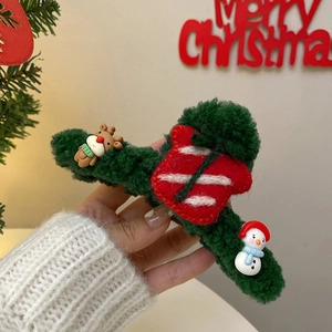 Detail of dark green plush Christmas hair claw clip with festive elk and snowman charms