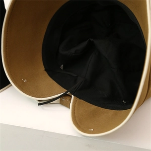 Detail of khaki fisherman hat with black lining, white edge piping and windproof rope