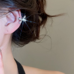 Close-up of elegant silver bow ear cuff with sparkling zircons worn by a model
