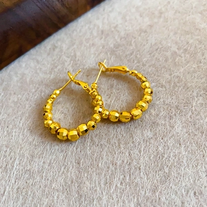 Minimalist geometric golden bead hoop earrings featuring a polished metallic luster design