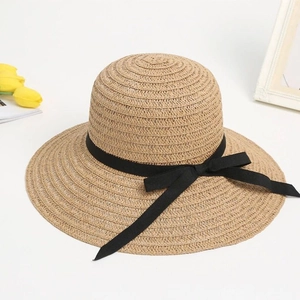 Dettaglio cappello di paglia intrecciato con elegante fiocco nero per spiaggia e sole