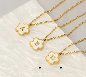 Detail of 18K gold-plated stainless steel flower necklaces with A, B, C shell letter charms
