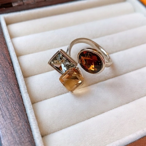 Three-stone open ring with silver finish and amber geometric gems in a velvet box