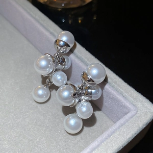 Dettaglio di eleganti orecchini con perle a grappolo e finiture in argento in scatola