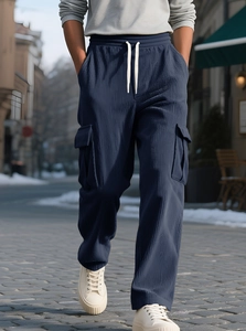 Detail of dark blue corduroy cargo pants featuring cream drawstring and texture