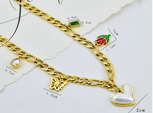 Detailed view of chunky gold chain necklace with heart, butterfly and tulip charms