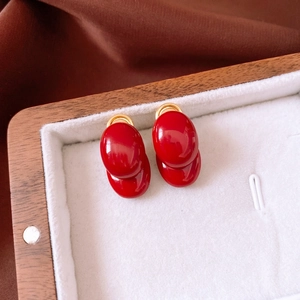 Elegant 18K gold-plated oval red stud earrings displayed in a vintage jewelry box