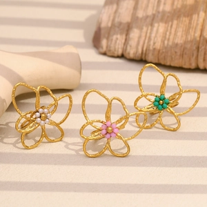 Detailed view of 18K gold plated rings with colorful beaded flower designs and shadows