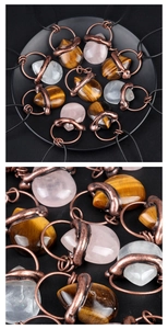 Detail showing vintage acorn-shaped tiger eye and rose quartz crystal pendants on copper