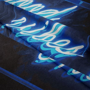 Detail shot of the blue bohemian tapestry fabric showing soft fiber texture and art script
