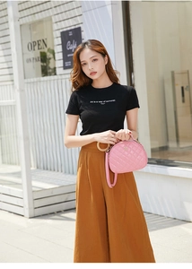 Outdoor street style view of a pink quilted crossbody bag paired with a casual outfit