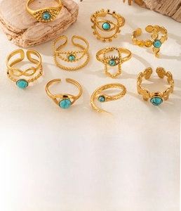 Detailed close-up of bohemian gold plated titanium steel rings with turquoise inlay
