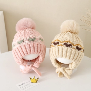 Winter knit earflap hat for kids with pompom and heart pattern in pink and beige