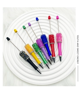 Detail of colorful DIY crystal bead pens set arranged on a white tiered display stand