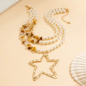 Detail of layered necklace with star pendant, white pearls and turquoise beads