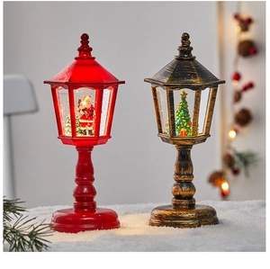 Classic Christmas lantern ornaments with Santa and tree motifs on a snowy display