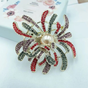 Detail of luxury firework brooch with colorful rhinestones and a large center pearl
