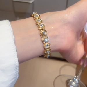 Detailed view of luxury gold elastic bracelet with inlaid round diamonds on model wrist