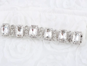 Détail de la chaîne élégante en strass de cristal sur un tissu en dentelle blanche