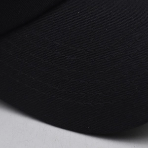 Détail macro de la casquette de baseball en coton noir montrant des coutures parallèles