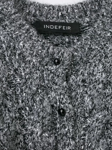 Detail of mixed-knit cardigan featuring smooth black buttons and woven neckline label