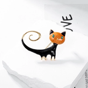 Detail of artistic cat brooch with green gem eyes on natural stone background