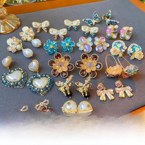 Detailed close-up of crystal flower earrings with gold plating and pearl accents