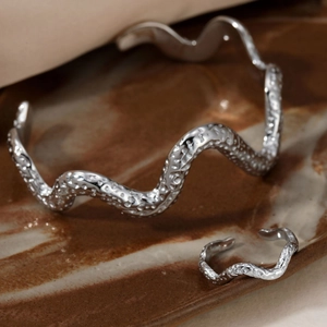 Silver stainless steel wavy bracelet and ring set with hammered texture on ceramic tray